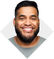 Un hombre con barba sonriente y con una camiseta gris
