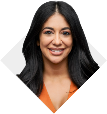 Una mujer de cabello lacio castaño oscuro, sonriente y con una camisa naranja